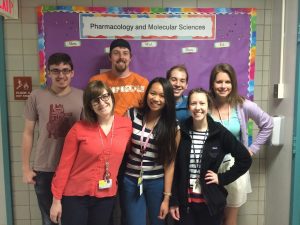 A photo featuring some of the PSI Council members standing in front of their department bulletin board.