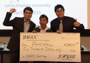 Byung-Hak Kang, Weijie Poh, and Joshua Wang pose with their first prize check for $2,000 from the JHGCC Biotech and Healthcare Case Competition