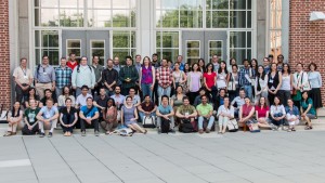 Attendees of STI standing and sitting outside of a building for a portrait 