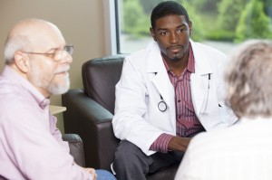 A doctor talks to an elderly couple.