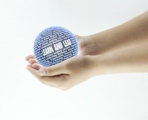 Photo of a  person holding a ball made up of leadership words and phrases.