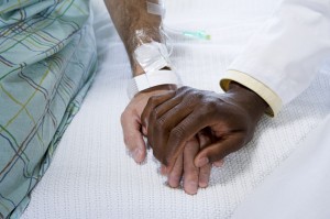 A doctor holding a patient's hand.