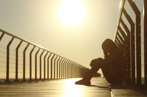 girl sitting on a bridge at sunset