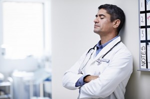 a doctor reflecting with his eyes closed