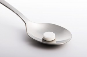 one white pill in a spoon