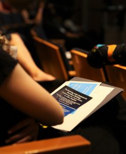 student sits at a chair looking at a pamphlet titled "partnering with patients in decision making"