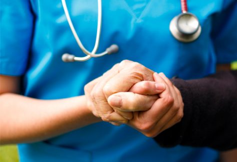 nurse holds a patient's hand