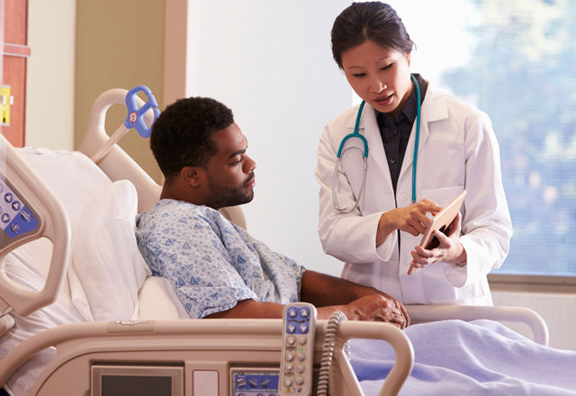 doctor showing her patient a test result on a tablet at the bedside