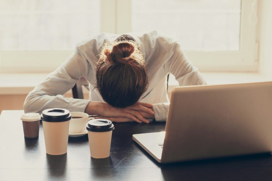 tired woman with her head on her desk