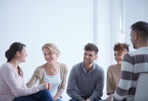 A group of young people sit and talk together.