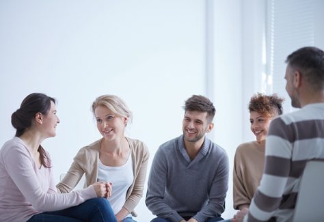 A group of young people sit and talk together.