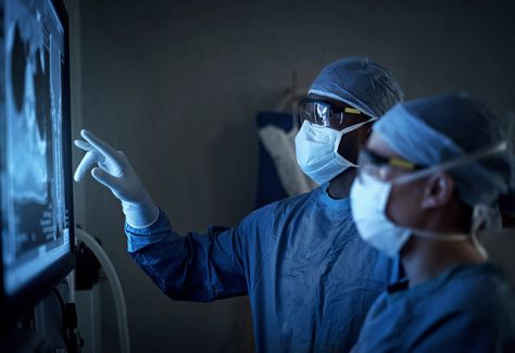 Two surgeons analyzing a patient’s medical scans.
