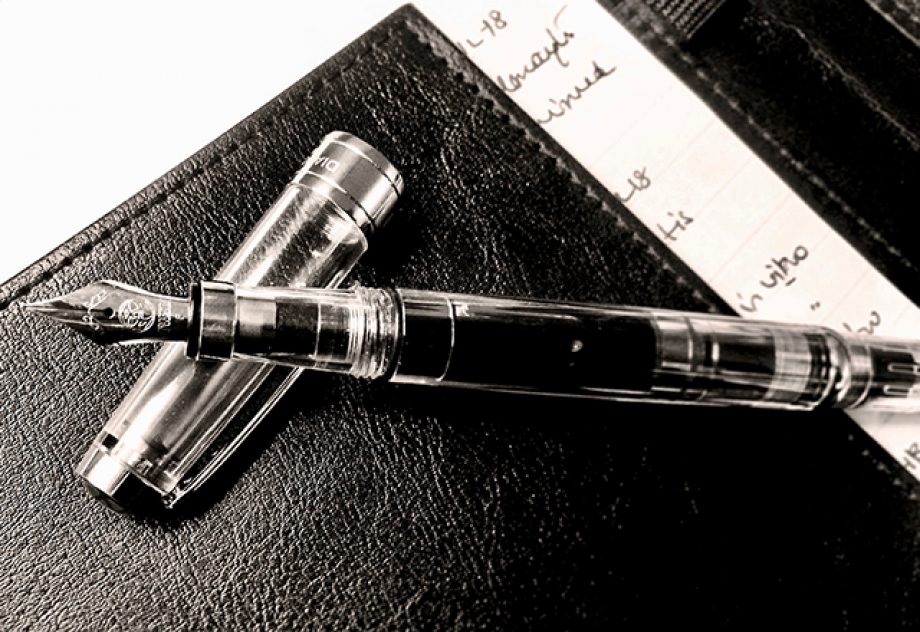 A black-and-white image of a fountain pen resting atop a notebook, taken by the author.