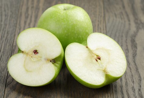 Green apples on a cutting board.