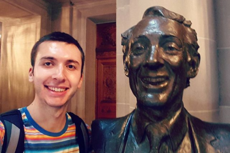 David Ottenheimer poses with the statue of Harvey Milk in San Francisco City Hall.
