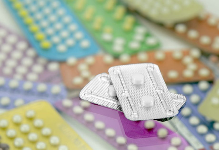 Emergency contraceptive pills on pharmacy counter with colorful pills strips background.