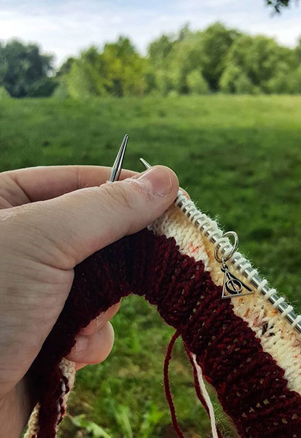 A woman knits outdoors.