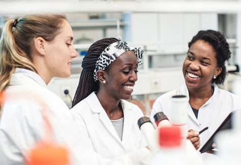 A diverse group of female scientists work together in the lab.