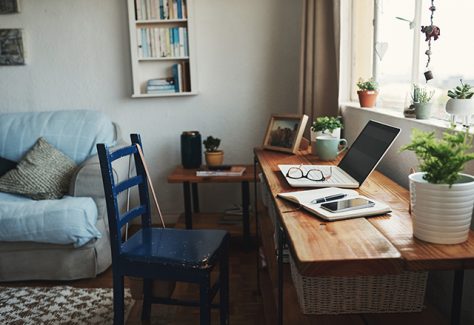 Cropped shot of technology and a notebook on a desk in an empty home office during the day.