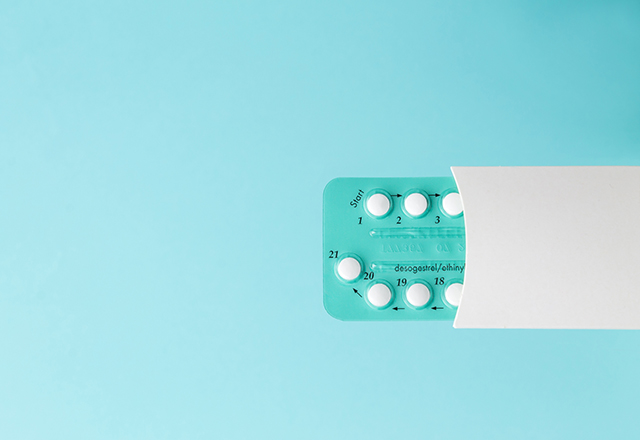 Pack of oral contraceptive pills on a blue background.