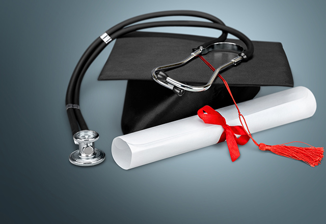 A graduation cap with a diploma and stethoscope.