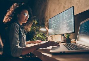 A female programmer working on code at her computer.