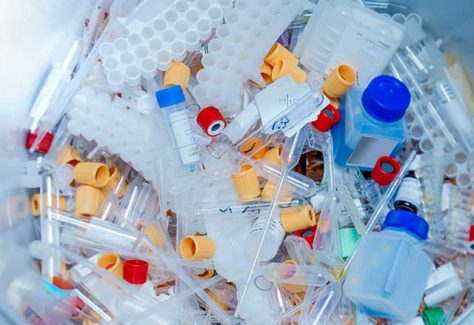 A trash bin filled with single use plastics used in biomedical research.