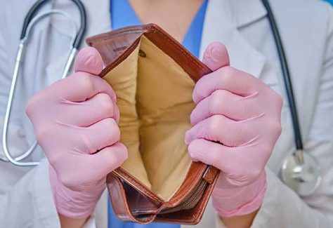 A medical professional opening an empty wallet.