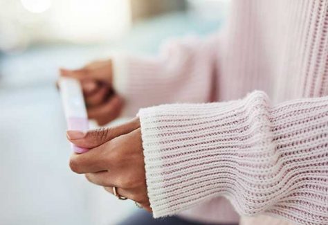 Woman holding a pregnancy test.