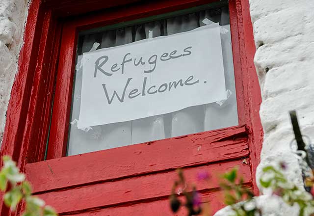 Refugees welcome sign on a door.