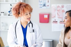 Young female doctor discusses health concerns with patient during appointment