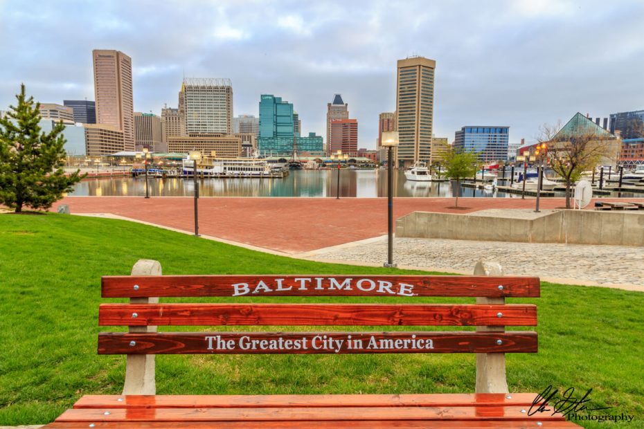 Baltimore bench reading "Baltimore Greatest City in the America" in front of the Inner Harbor