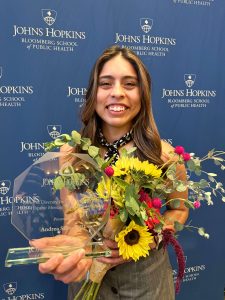 Andrea Silvas, M.D. smiles at camera with flowers