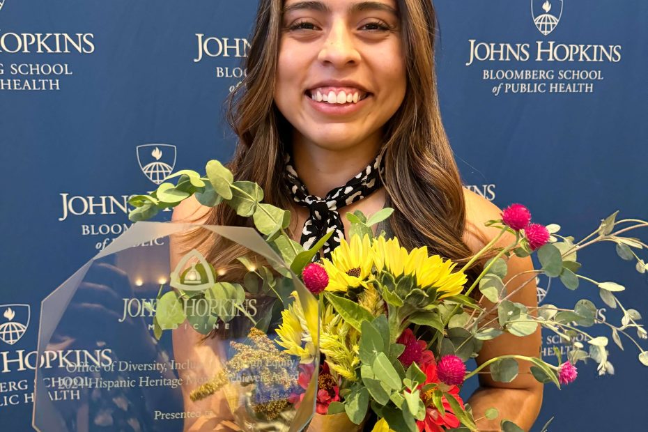 Andrea Silvas, M.D. smiles at camera with flowers