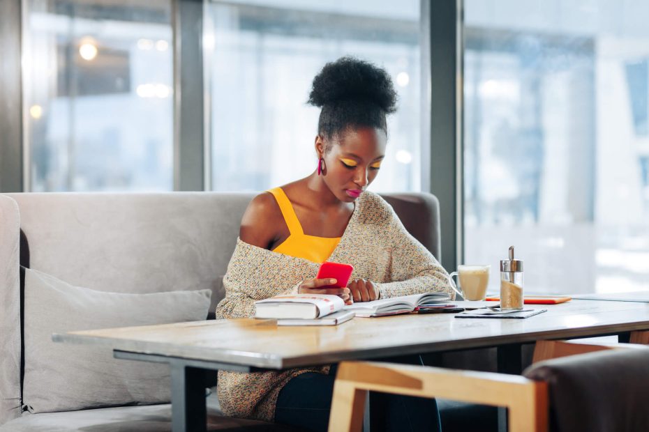 Smart diligent student feeling busy while getting ready for exam sitting in cafeteria