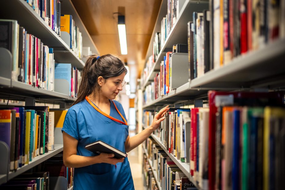 female intern doing research in the library to study