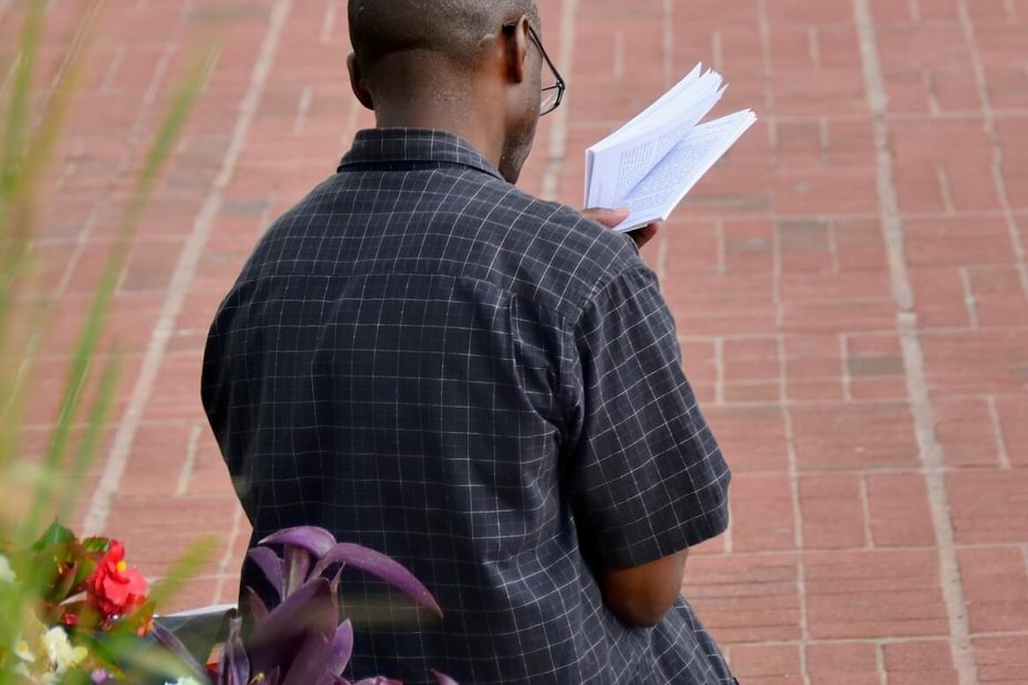 Baltimore, USA - June 6, 2012: A man reading his book at the busy Baltimore's Inner Harbor. The Inner Harbor area is full of restaurants and stores and a major tourist attraction of Baltimore.