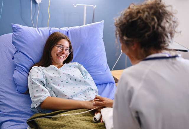 Close-up of a smiling teenage patient talking with her doctor in the hospital