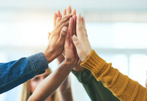 Closeup shot of a diverse group of people high fiving together
