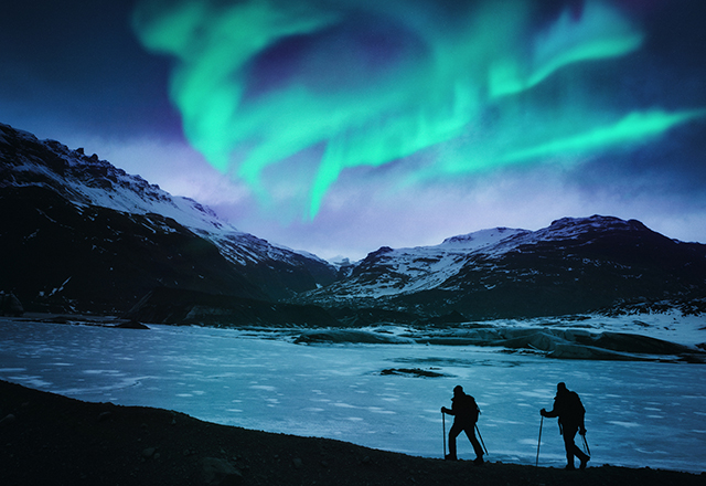 Hikers under the northern lights in Iceland.