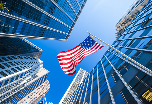 USA flag and contemporary glass architecture of Financial District, New York City, USA.