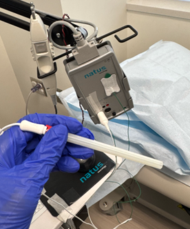Close-up of NCS/EMG machine used in clinic with EMG needle connected to the machine and electrical stimulator in the top left.