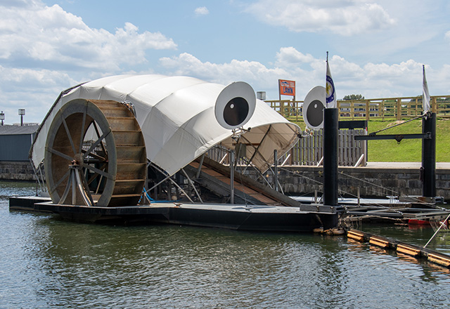 The Inner Harbor Water Wheel, often called Mr. Trash Wheel, scoops up trash from the Jones Falls waterway, preventing it from entering the Inner Harbor in Baltimore, Maryland. Powered by water wheels and solar panels, the device collects trash from the stream using a conveyor belt and places it in a dumpster.