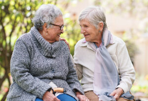 Outdoor, friends and bench with senior women, love and bonding together with retirement, park and cheerful. Old ladies, outside and mature people with conversation, group and joy with weekend break