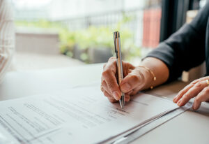 Detail of human hand signing contract