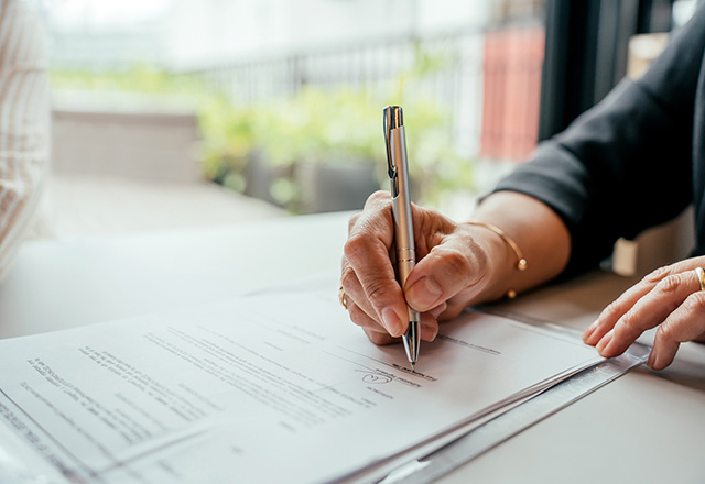 Detail of human hand signing contract